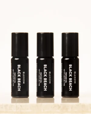 bluxom black beach roll-on perfume oil in a sleek black bottle with coastal sage, sea salt, and soft wood notes.